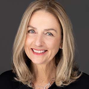 A portrait of Donna Rogers. She is an older white woman with blonde wavy hair and a black blouse