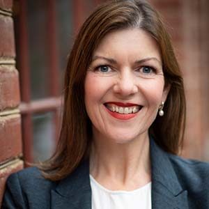 A portrait of Jane Cunningham. She is a white woman with long brown hair and a blue suit jacket