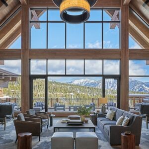 A lounge in Montage Big Sky Montana. The cabin wall is glass, showing the mountains outside