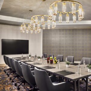 A boardroom at Sheraton San Diego Hotel and Marina. Chandeliers are above the table with grey office chairs