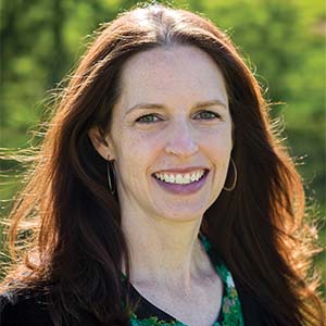 A portrait of Victoria Fanning. She is a white woman with auburn hair and a black cardigan