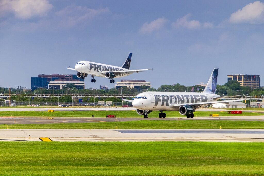 Two Frontier Airlines planes at a runway