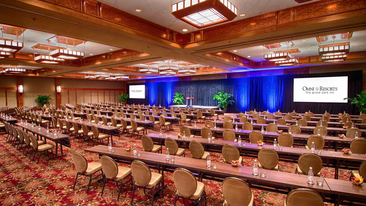 A convention center at Omni Resorts with long tables and red, patterned carpet.