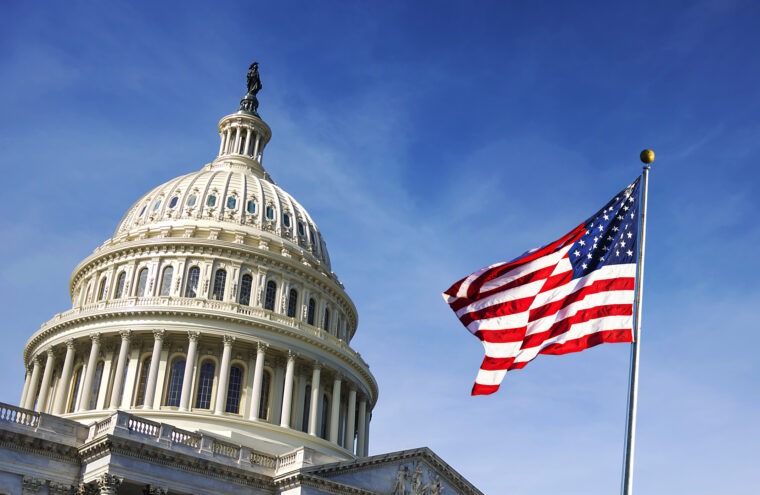 The dome of the White House with an American flag in the foreground