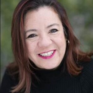 A portrait of AnaLaura Becerra. She is a white woman with shoulder-length brown hair and a black sweater.