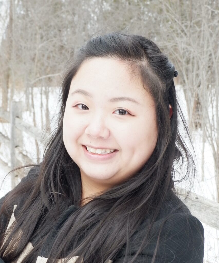 A portrait of Amy Shen, a young Asian woman with long dark hair and a black hoodie.