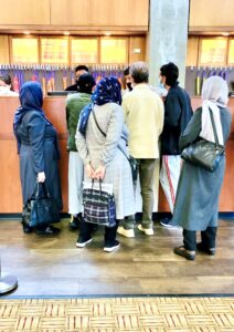 A group of Hijabi women standing at a counter in the National Conference Center.