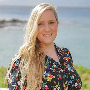 A portrait of Jessica Candy. She is a white woman with blonde hair and a black floral blouse.