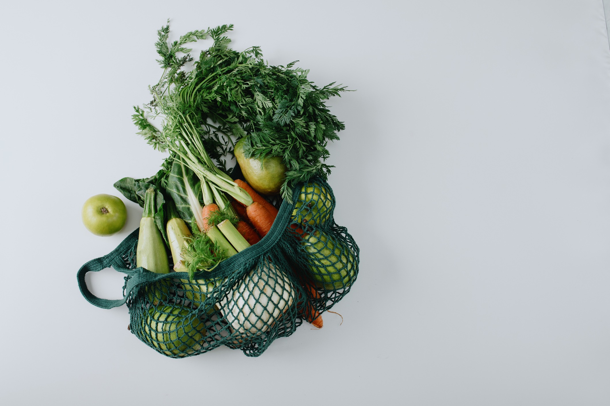 Fresh produce in a loosely-knit fabric bag.