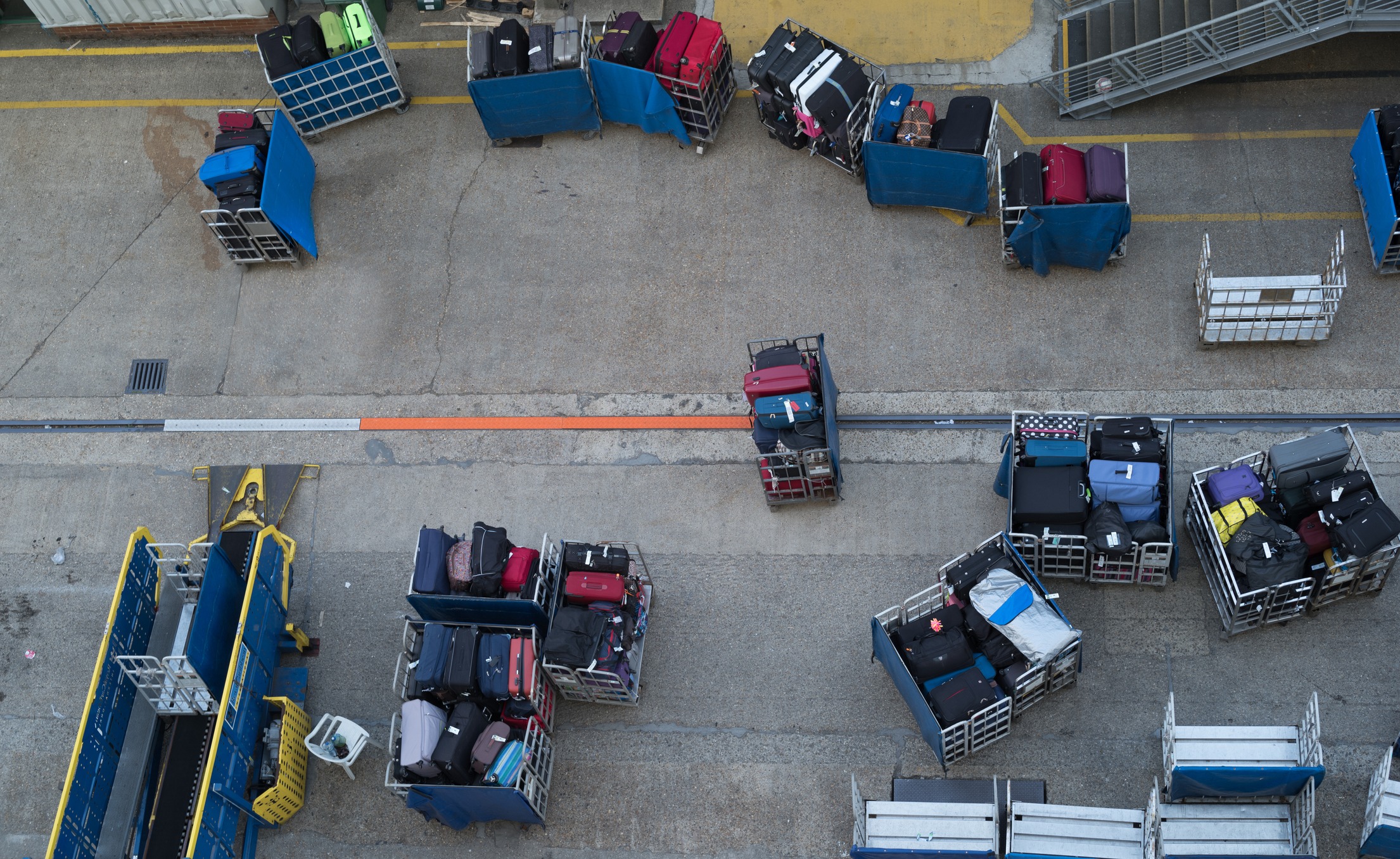 An overhead shot of baggage being loaded onto a plane.