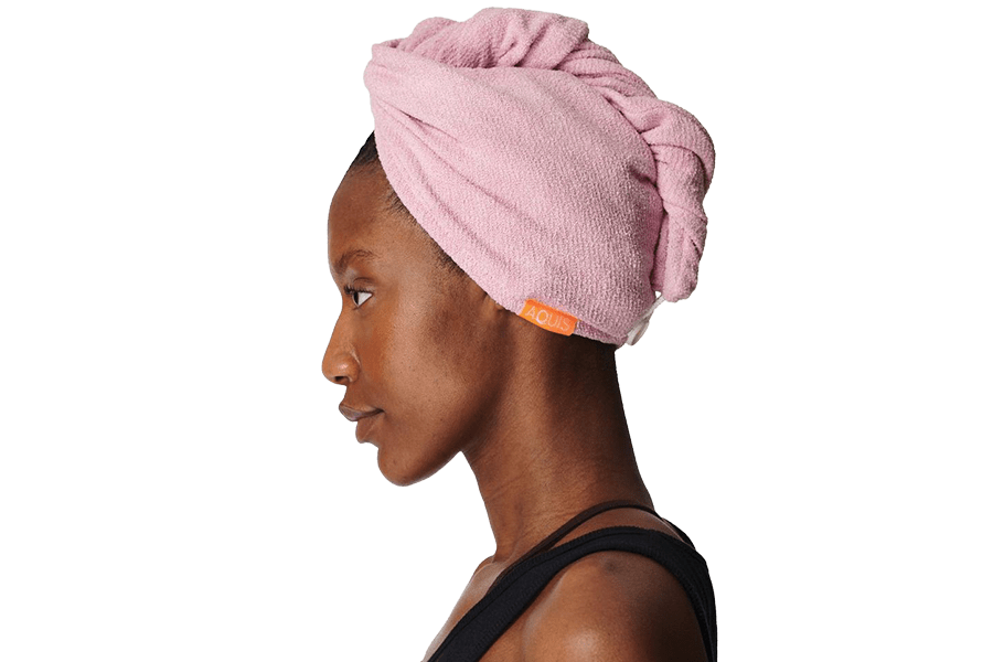A black woman in profile wearing a pink Aquis hair wrap towel.