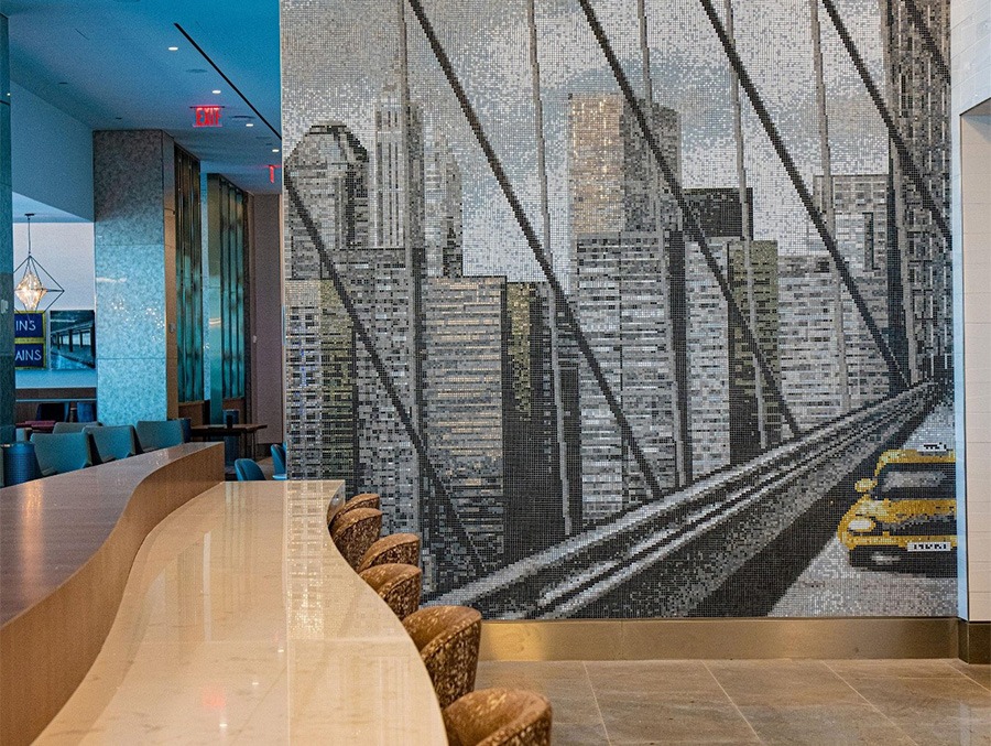 Delta’s new SkyClub at LGA’s Terminal C. The wall has a mosaic of the New York skyline with a taxi.
