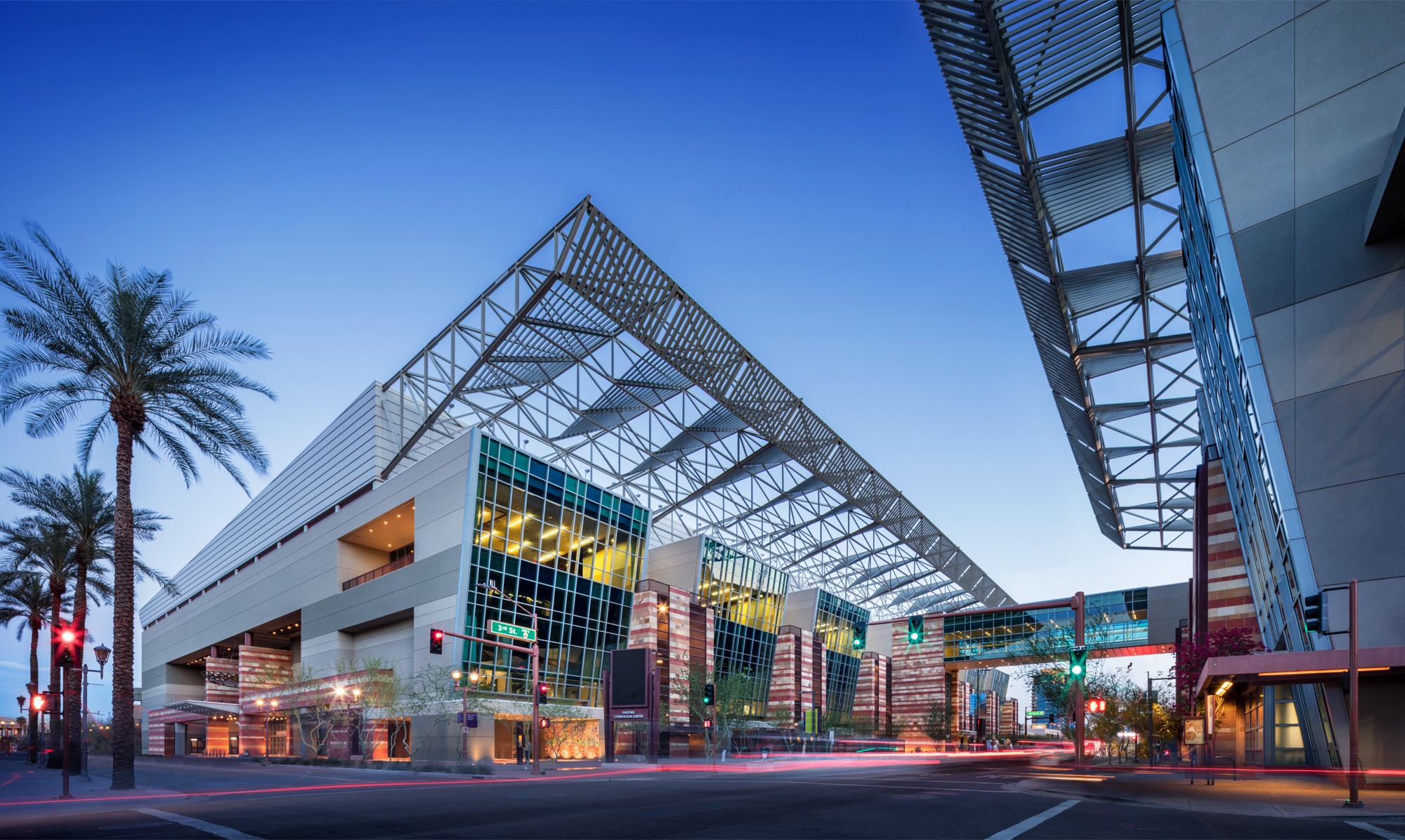 The exterior of the Phoenix Convention Center. There are two main buildings with a glass walkway connecting them. 