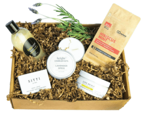 A cardboard box with various spa items in brown paper