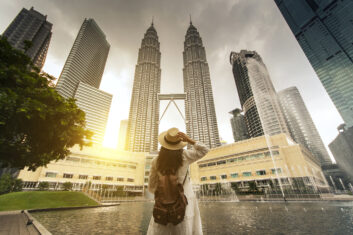 Woman tourist looking at Kuala Lumpur twin tower in Malaysia