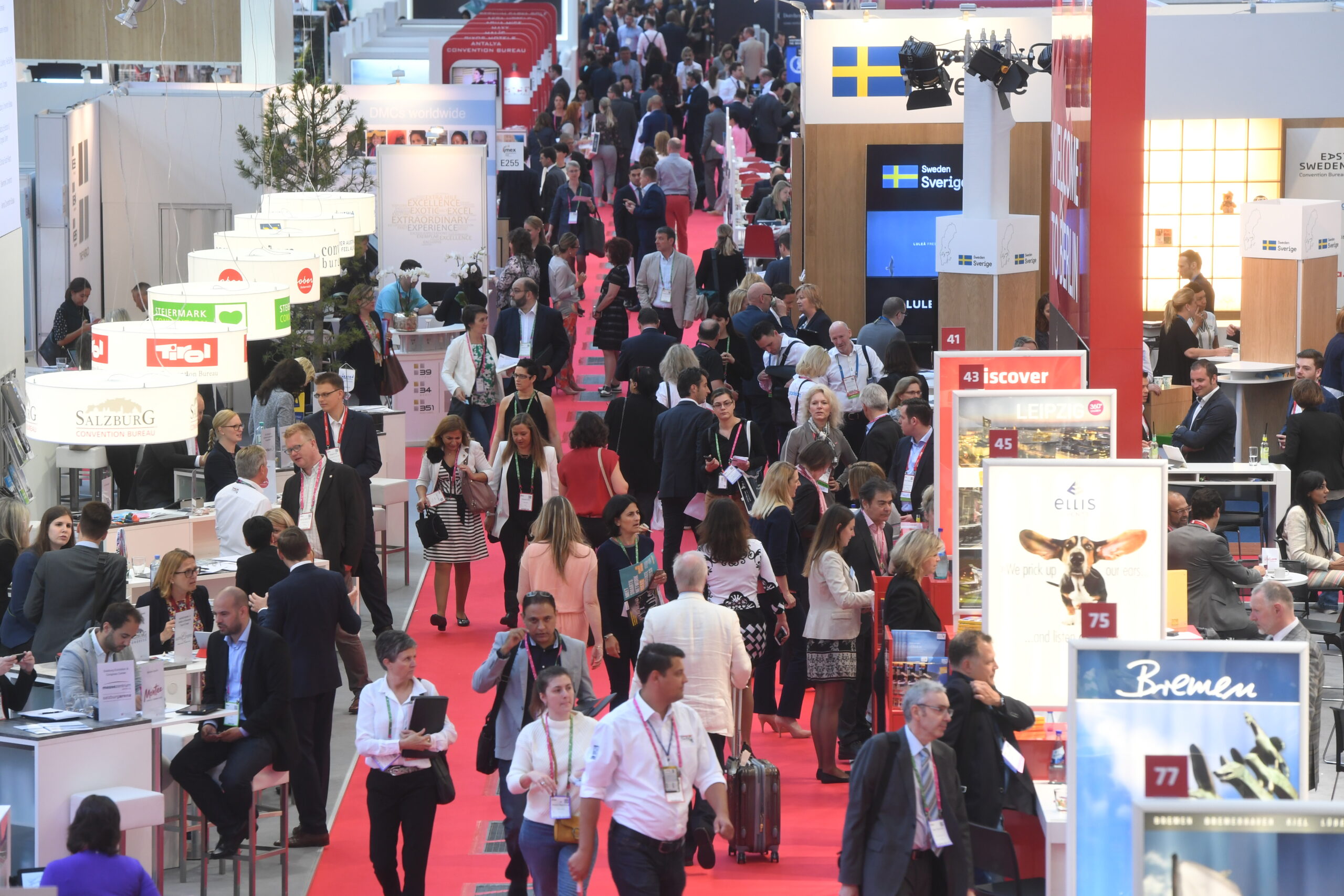 businesspeople walking and looking at booths at imex frankfurt