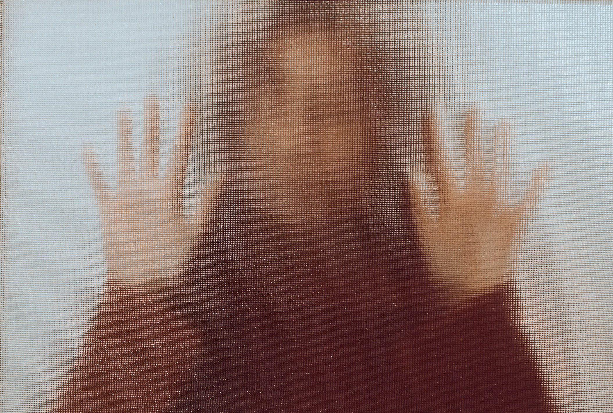 Blurred Image of Women with hands against glass