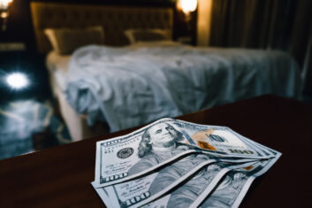 Several hundred dollar bills on a table in a hotel room