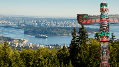 First Nation totem pole in foreground and Vancouver, british columbia, in backgroun