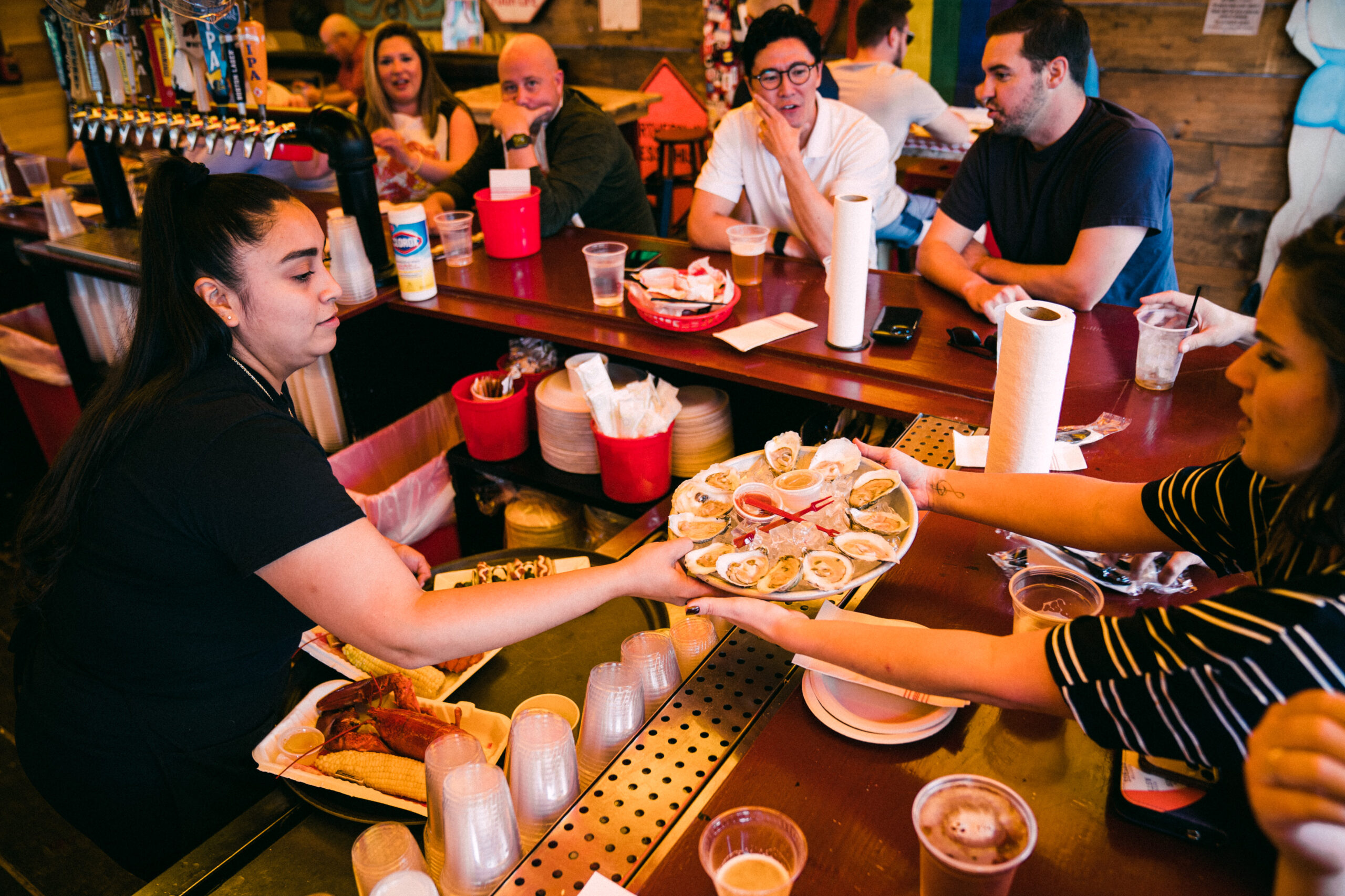 woman passing oysters to customer at the Barking Crab in boston