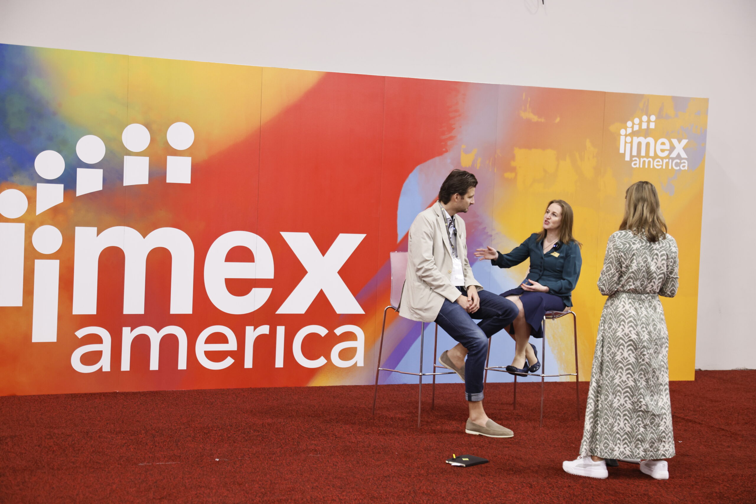 imex ceo carina bauer talking with someone at imex event