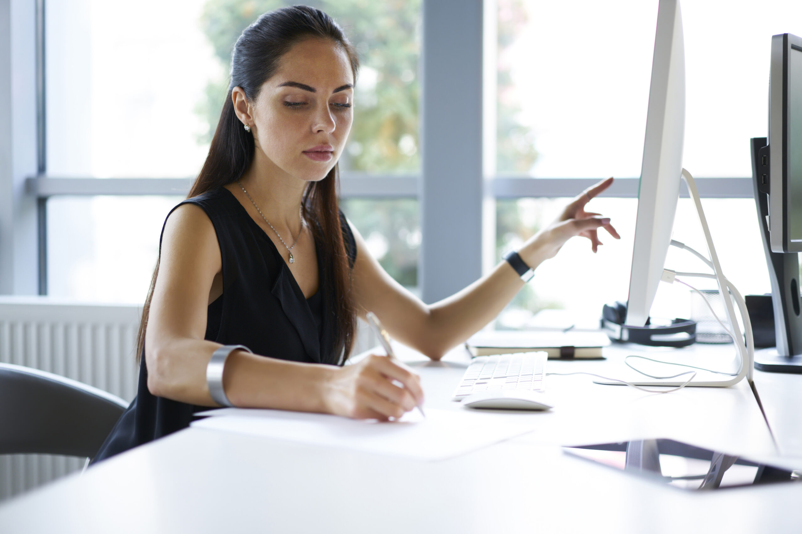 Concentrated professional female journalist browsing information using computer in office