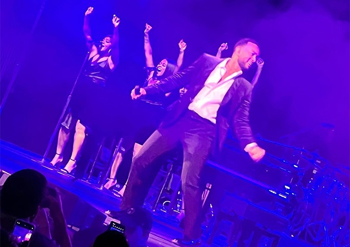 john legend dancing and singing on stage at pcma convening leaders