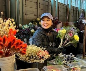 Lue Eng handling flowers surrounded by bouquet of flowers