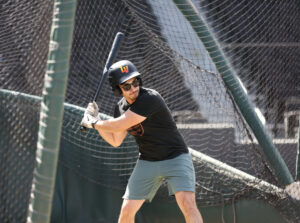 man swinging bat at Las Vegas Ballpark Batting Cages