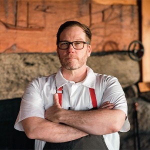 Patrick Meany crossing arms, wearing white chef shirt