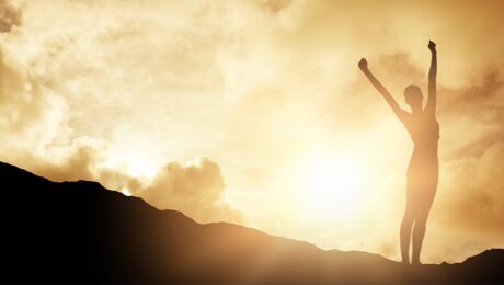 woman standing outside against blue sky with white clouds