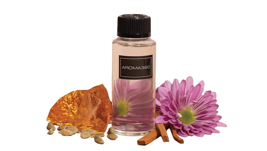 small bottle of oil next to flowers