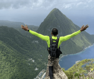 man standing on top of mountain with arm outstretched