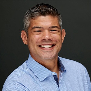 man smiling, wearing light blue button up shirt